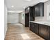 Modern kitchen with dark cabinets, stainless appliances and view into the living room at 1480 Bettis Tribble Gap Rd, Cumming, GA 30040