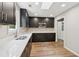 Modern kitchen features dark cabinetry, stainless steel appliances, and quartz countertops at 1480 Bettis Tribble Gap Rd, Cumming, GA 30040
