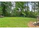 Spacious backyard with lush green grass and mature trees providing shade and privacy at 1617 Columbia Cir, Decatur, GA 30032