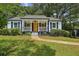 Charming home features a landscaped yard, inviting porch, and cheerful yellow front door at 1617 Columbia Cir, Decatur, GA 30032