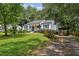 Well-maintained home with a driveway and lush lawn, surrounded by mature trees at 1617 Columbia Cir, Decatur, GA 30032