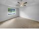 Bright bedroom features plush carpeting, ceiling fan, and a window with backyard view at 230 Myrtle Grove Ln, Covington, GA 30014