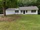Traditional home with attached garage and inviting front porch, set amidst a partially wooded lot at 230 Myrtle Grove Ln, Covington, GA 30014