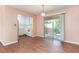 Bright dining area with wood-look flooring, sliding glass doors to the balcony, and an adjacent kitchen at 4266 Roswell Ne Rd # H4, Atlanta, GA 30342