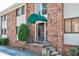 Exterior view of a brick condominium building, showcasing the entrance with a green awning and unit number H at 4266 Roswell Ne Rd # H4, Atlanta, GA 30342