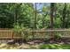 A wooden picket fence bordering a landscaped backyard and lush greenery at 126 Woodbury Ln, Canton, GA 30114