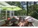 Deck with patio furniture, an umbrella, grill, and a view of the woods at 126 Woodbury Ln, Canton, GA 30114