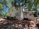 Exterior view of the back of the house featuring a screened in porch, brick foundation, and some mature trees at 1789 Springhouse Ct, Lawrenceville, GA 30043