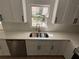 Modern kitchen sink and faucet surrounded by new white countertops and cabinets at 1789 Springhouse Ct, Lawrenceville, GA 30043