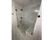 Walk-in shower featuring white marble walls, mosaic tile flooring and black hardware at 1789 Springhouse Ct, Lawrenceville, GA 30043