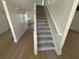 Staircase with carpeted stairs, modern banister and views of the kitchen and living areas at 1789 Springhouse Ct, Lawrenceville, GA 30043