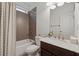 Well-lit bathroom featuring tiled shower over tub, modern fixtures, and a stylish vanity with a marble countertop at 236 Lakestone Pkwy, Woodstock, GA 30188