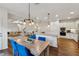 Dining room with wooden table and blue chairs near an island with an open-concept layout at 236 Lakestone Pkwy, Woodstock, GA 30188