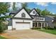 A two-story home with a two-car garage, stone accents, and well-maintained landscaping at 236 Lakestone Pkwy, Woodstock, GA 30188