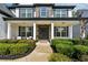 Inviting front porch with stone pillars, seating, and manicured hedges at 236 Lakestone Pkwy, Woodstock, GA 30188