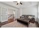Bright living room features hardwood floors, a cozy sofa, and elegant French doors leading to staircase at 236 Lakestone Pkwy, Woodstock, GA 30188