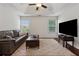 Comfortable living room with a plush sofa, a modern TV, and hardwood floors, creating a welcoming and stylish space at 236 Lakestone Pkwy, Woodstock, GA 30188