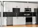 Modern kitchen features stainless steel appliances, white cabinetry and black countertops at 923 Peachtree Ne St # 932, Atlanta, GA 30309