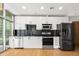 Well-appointed kitchen featuring modern appliances, white cabinets, and black backsplash at 923 Peachtree Ne St # 932, Atlanta, GA 30309