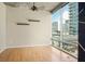 Empty living room featuring hardwood floors, concrete ceilings, and large windows with city views at 923 Peachtree Ne St # 932, Atlanta, GA 30309