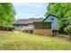 Back exterior of a home with a screened-in porch and wooden deck, surrounded by a well-manicured lawn at 9055 Green Valley Ct, Douglasville, GA 30134