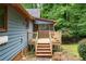 Exterior of a home featuring a wooden deck and screened-in porch, surrounded by lush greenery at 9055 Green Valley Ct, Douglasville, GA 30134