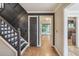 View of the home's foyer with wooden staircase and floors and black accent wall at 9055 Green Valley Ct, Douglasville, GA 30134