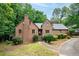 Charming brick home featuring mature trees, a walkway, and a covered entrance, offering a blend of classic and modern design at 9055 Green Valley Ct, Douglasville, GA 30134