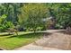 View of the home from the street, with mature trees and landscaping at 9055 Green Valley Ct, Douglasville, GA 30134
