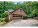 Home's garage and driveway surrounded by lush, mature landscaping at 9055 Green Valley Ct, Douglasville, GA 30134