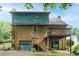 Two-story brick home with a wooden deck and attached garage, set in a lush, green landscape at 9055 Green Valley Ct, Douglasville, GA 30134