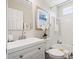 The well-lit bathroom boasts a white vanity and mirror, framed artwork, and decorative flowers at 1345 Benbrooke Nw Ln, Acworth, GA 30101