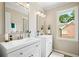 Bright bathroom featuring dual sinks, modern fixtures, and a view to the outdoor landscape at 1345 Benbrooke Nw Ln, Acworth, GA 30101