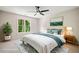 Staged bedroom with natural light, modern ceiling fan, and a scenic landscape painting at 1345 Benbrooke Nw Ln, Acworth, GA 30101