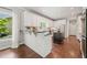 The bright kitchen boasts white cabinetry, dark countertops, a center island, stainless appliances and hardwood floors at 1345 Benbrooke Nw Ln, Acworth, GA 30101