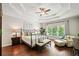 Spacious primary bedroom with tray ceilings, hardwood floors, large windows, and a comfortable seating area at 1345 Benbrooke Nw Ln, Acworth, GA 30101