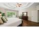 Well-lit primary bedroom with hardwood floors, tray ceilings, large window, and modern decor at 1345 Benbrooke Nw Ln, Acworth, GA 30101