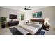 A spacious bedroom features a modern bed, gray and blue accents, tv, ceiling fan, and plenty of natural light at 1345 Benbrooke Nw Ln, Acworth, GA 30101