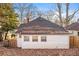 View of back exterior with white siding, roof, and windows surrounded by trees, foliage, and a wooden fence at 1015 Deckner Sw Ave, Atlanta, GA 30310