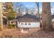 View of back exterior with white siding, roof, and windows surrounded by trees, foliage, and a wooden fence at 1015 Deckner Sw Ave, Atlanta, GA 30310