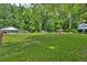 Spacious backyard featuring a pool, outbuildings, large trees, and plenty of grass for outdoor activities and relaxation at 146 Henderson Farm Ln, Canton, GA 30115