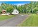 Long driveway leading to a charming white home with a large yard and mature trees at 146 Henderson Farm Ln, Canton, GA 30115