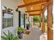 Cozy covered front porch with wood support beams and potted plants, creating a welcoming outdoor space at 146 Henderson Farm Ln, Canton, GA 30115