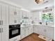 Bright white kitchen with modern black hardware, stone countertops, and updated appliances at 146 Henderson Farm Ln, Canton, GA 30115