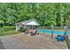 Backyard pool area surrounded by lush greenery, featuring lounge chairs and outdoor decor at 146 Henderson Farm Ln, Canton, GA 30115