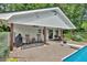 Inviting poolside patio area with rocking chairs, ceiling fans, and a convenient outdoor grill for summer entertaining at 146 Henderson Farm Ln, Canton, GA 30115