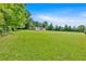 Expansive green lawn with a fenced perimeter surrounding a charming home under a clear blue sky at 146 Henderson Farm Ln, Canton, GA 30115