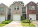 Townhome with brick and siding, featuring a garage and landscaped front yard at 5590 Stonewood Court Ct, Norcross, GA 30093