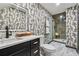 Modern bathroom featuring patterned wallpaper, marble floors, sleek black fixtures, and a glass-enclosed shower at 904 Ivy Green Se Ln, Marietta, GA 30067