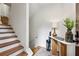 Entryway with wooden staircase, console table, modern lamp and verdant decor at 904 Ivy Green Se Ln, Marietta, GA 30067